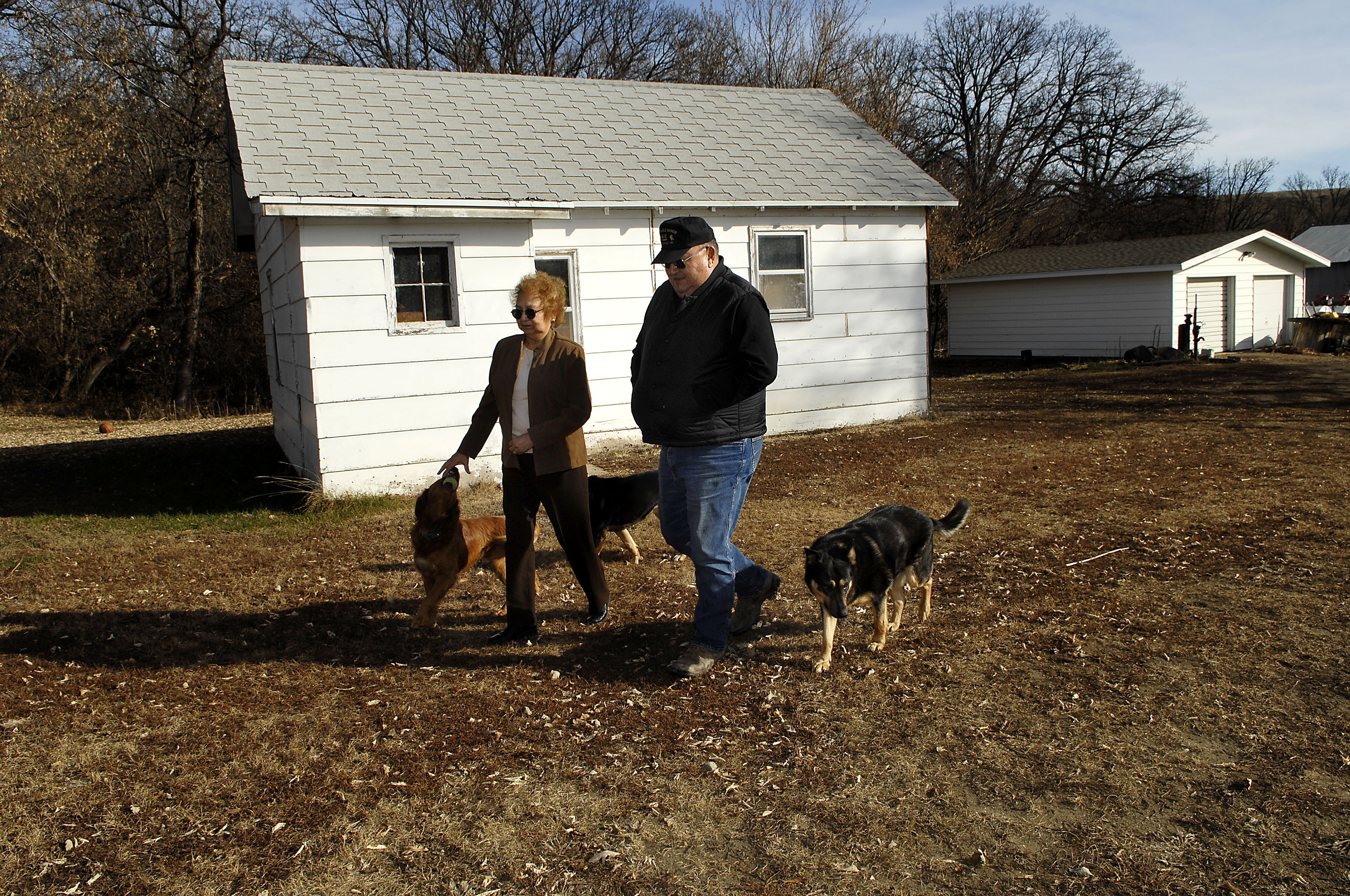 In this photo taken November 10, 2009, George and Marilyn Keepseagle walk past the house where George grew up, in Fort Yates , North Dakota. Photography: AP Photo/Will Kincaid