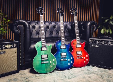 The Gibson LP Modern Figured guitar in green, blue, and red, leaning against a black leather couch in a recording studio.