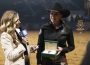 Sarah Dawson is interviewed by a journalist in the Globe Life Field arena as she holds a Rolex watch gifted to her for her win at the 2023 American Performance Horseman.