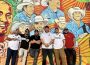 Members of Grupo Frontera stand in front of a mural.